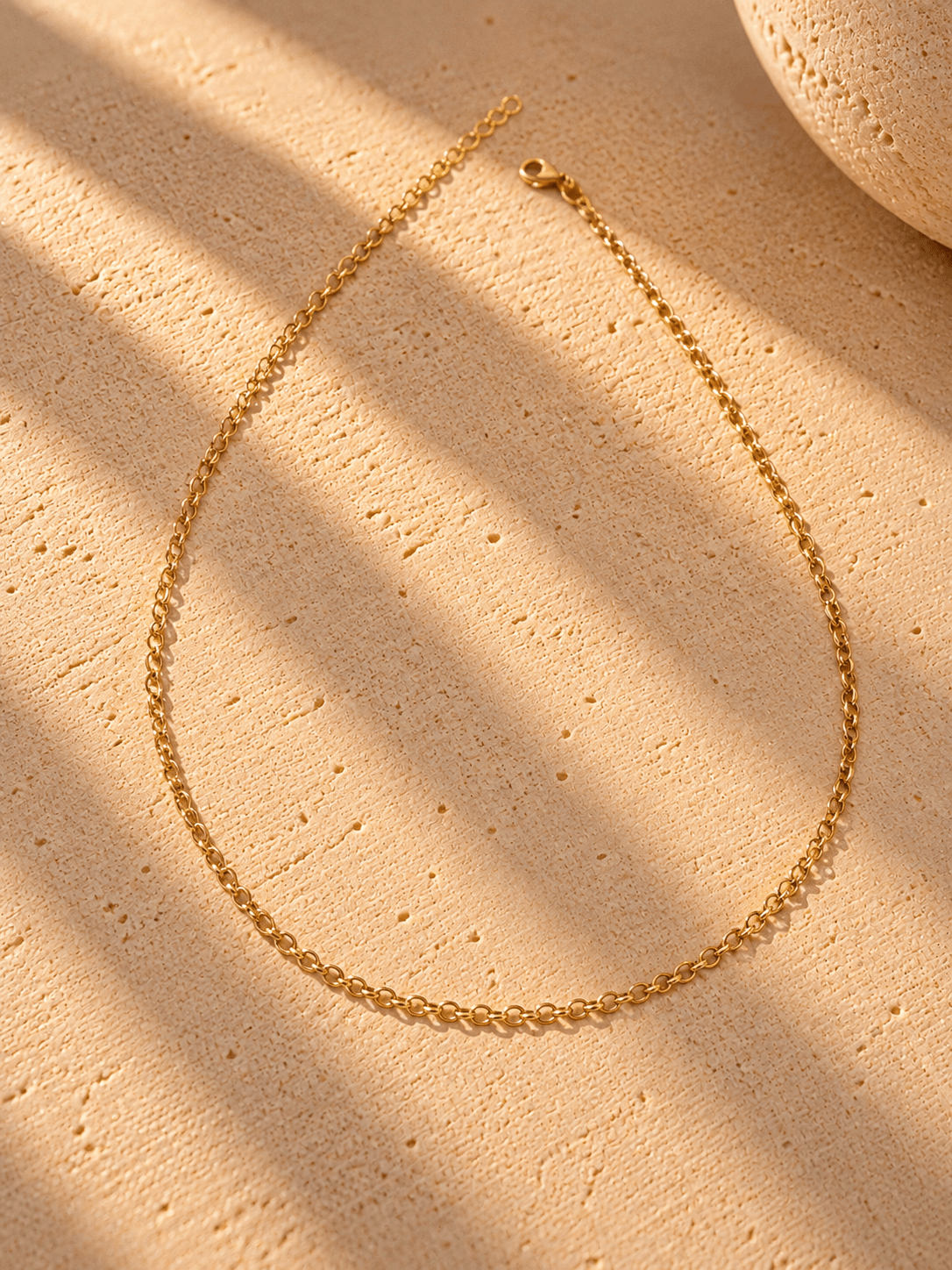 15624215756-colar-dourado-sobre-pedra-texturizada-1-1