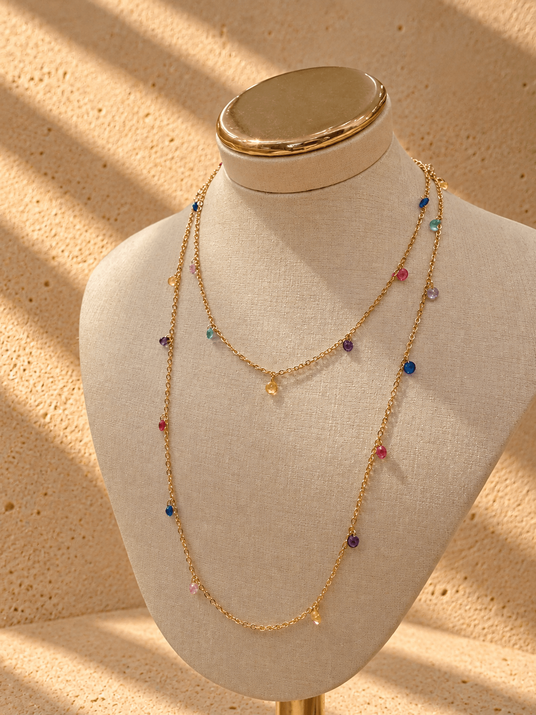 15625018666-colar-dourado-com-contas-coloridas-ao-sol-1