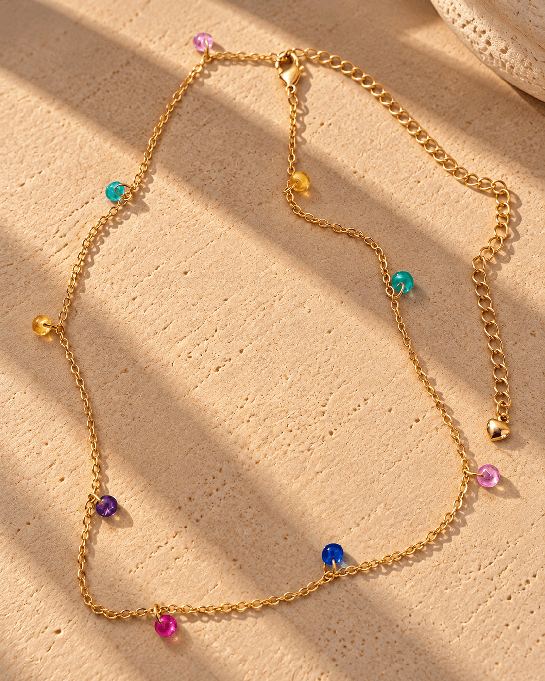 15625018666-colar-dourado-com-contas-coloridas-ao-sol-1