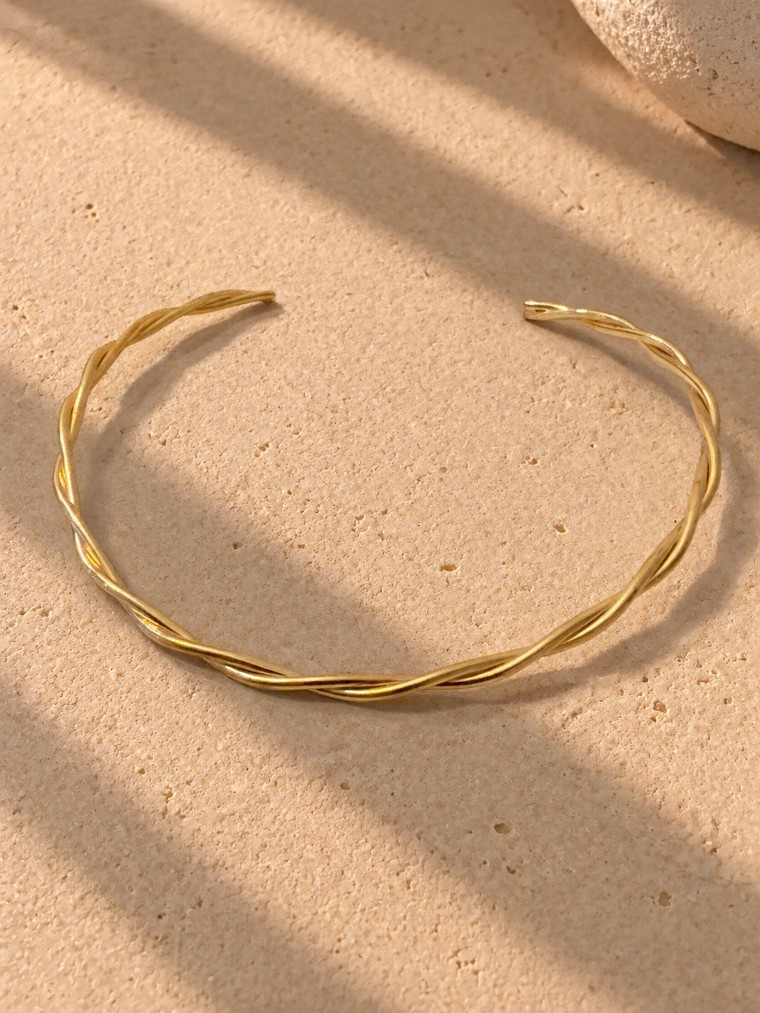 15625075012-bracelete-dourado-trancado-sobre-pedra-texturizada